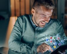 Get in touch through modern platforms—visual of a man exploring 3D social media icons emerging from his smartphone screen.